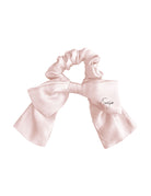 Pink silk bow scrunchie on a white background
